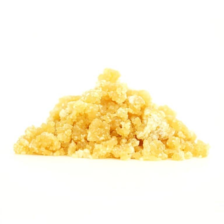 Golden cannabis sugar wax concentrate photographed on a crisp white background with visible crystal texture and natural depth