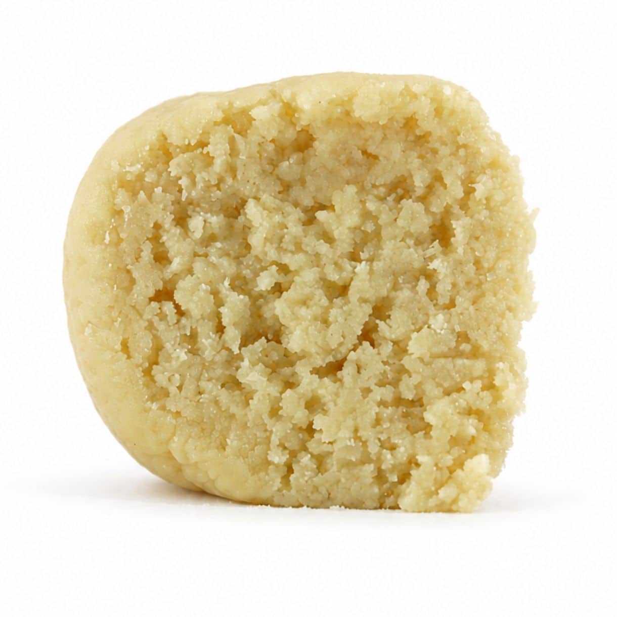 blueberry dream budder Close-up Pale yellow cannabis extract with a crumbly texture displayed upright on a white background