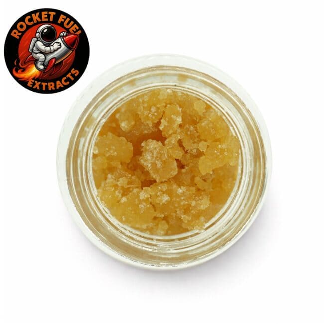 cannabis extract in a clear glass jar with golden sugar wax texture on a white background, Rocket Fuel Extracts branding visible