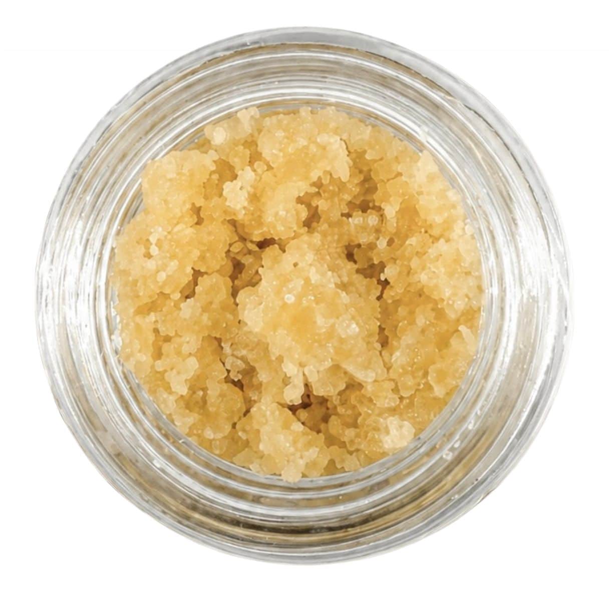 Open jar with golden, crumbly texture and granular consistency