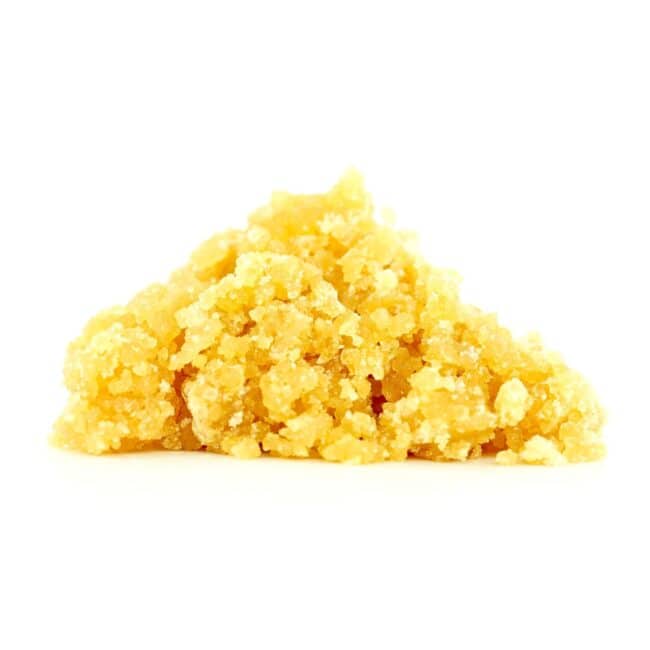 Golden cannabis sugar wax concentrate photographed on a crisp white background with visible crystal texture and natural depth
