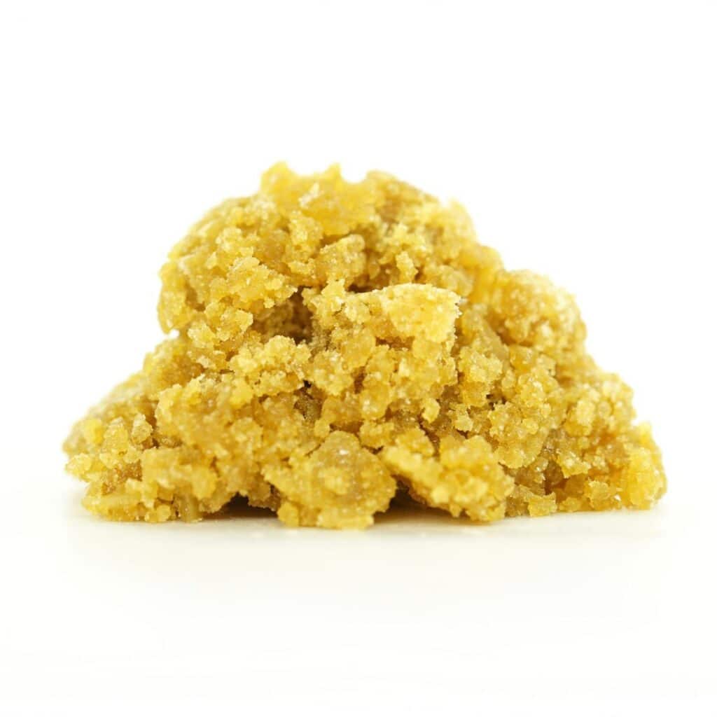 jealousy sugar wax Golden cannabis sugar wax concentrate photographed on a crisp white background with visible crystal texture and natural depth
