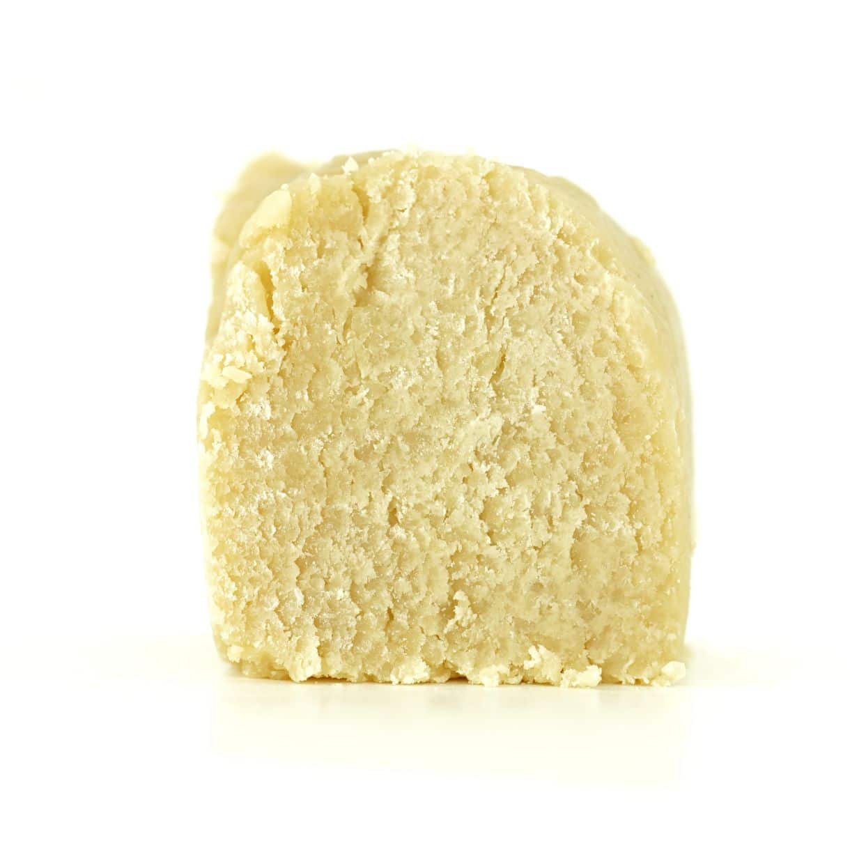 Close-up of a light yellow cannabis concentrate with a smooth, slightly crumbly texture on a white background.