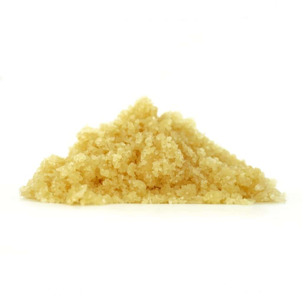 Golden cannabis sugar wax concentrate photographed on a crisp white background with visible crystal texture and natural depth