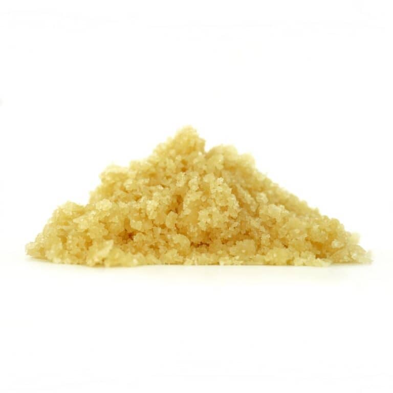 Golden cannabis sugar wax concentrate photographed on a crisp white background with visible crystal texture and natural depth
