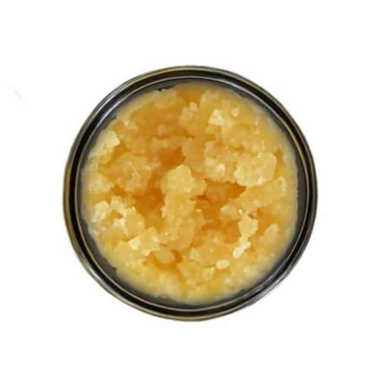 Open jar with golden, crumbly texture and granular consistency (close-up)