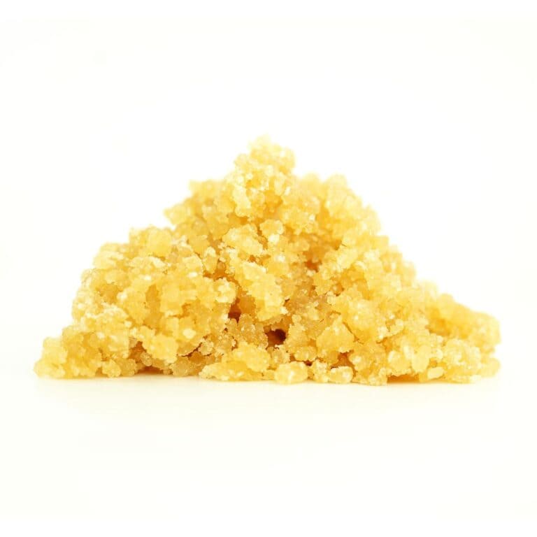 Golden cannabis sugar wax concentrate photographed on a crisp white background with visible crystal texture and natural depth