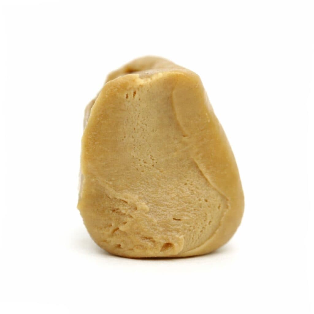 Photorealistic close-up of a light beige resin concentrate with smooth texture and natural contours on a crisp white background.