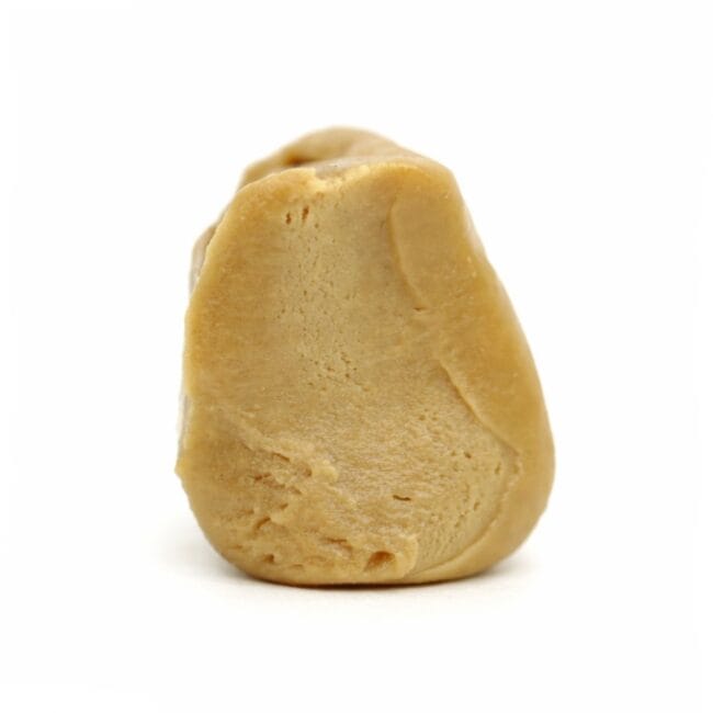 Photorealistic close-up of a light beige resin concentrate with smooth texture and natural contours on a crisp white background.