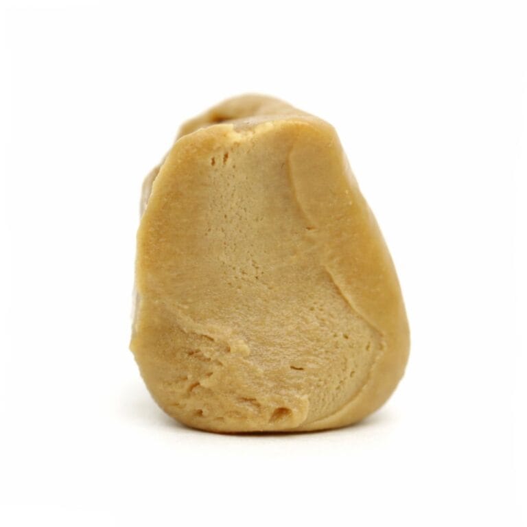 Photorealistic close-up of a light beige resin concentrate with smooth texture and natural contours on a crisp white background.