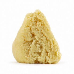 east coast sour diesel budder Close-up Pale yellow cannabis extract with a crumbly texture displayed upright on a white background