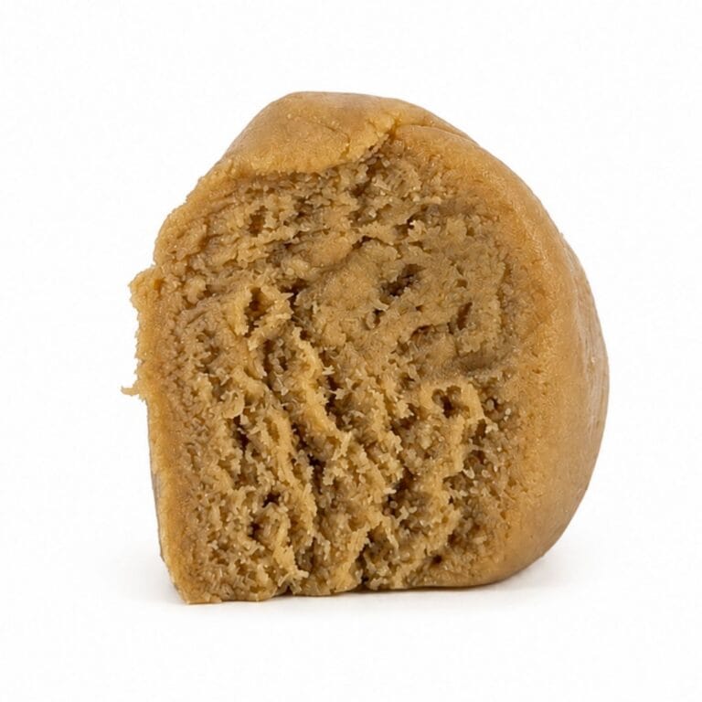 Premium light-golden cannabis concentrate with a smooth, dense texture, displayed as a sliced nug-style extract on a clean white background.