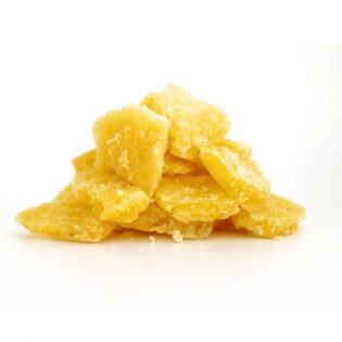 Photorealistic image of golden-yellow cannabis crumble stacked in a small pile on a crisp white background, showcasing detailed crystalline texture and slightly uneven, natural edges.