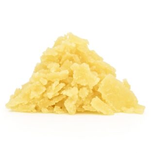 Golden-yellow cannabis concentrate with a flaky, crystalline texture, neatly piled on a clean white background, captured in sharp, natural lighting.