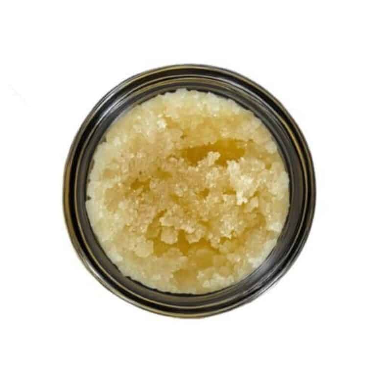 Open jar with golden, crumbly texture and granular consistency (close-up)