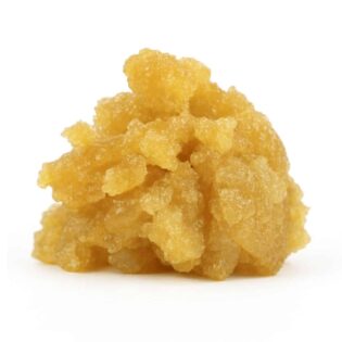 Golden cannabis concentrate with a moist, crystalline texture on a clean white background, showcasing its rich amber tones and granular structure