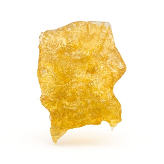 Photorealistic golden cannabis shatter piece on a crisp white background.