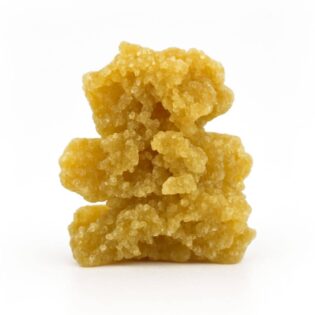 Golden-yellow cannabis crumble stacked in three uneven chunks on a crisp white background, showing detailed crystalline texture and natural colour variation.