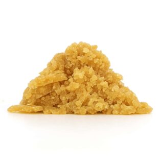 close-up of golden-brown cannabis concentrate crumble on a crisp white background, showing fine granules and realistic texture.