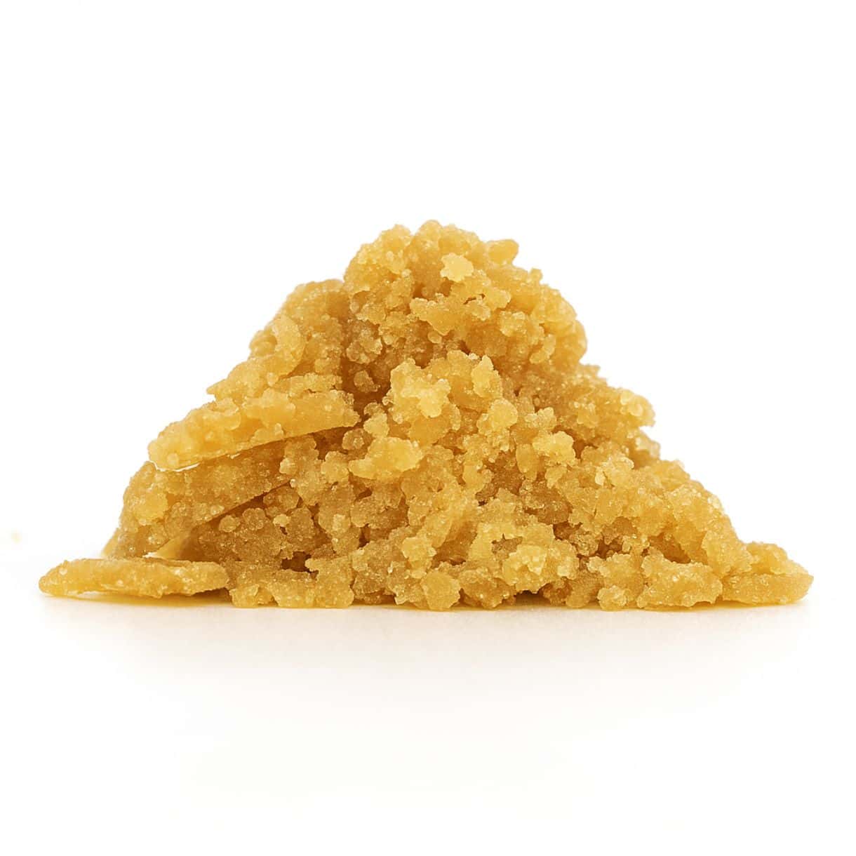 close-up of golden-brown cannabis concentrate crumble on a crisp white background, showing fine granules and realistic texture.