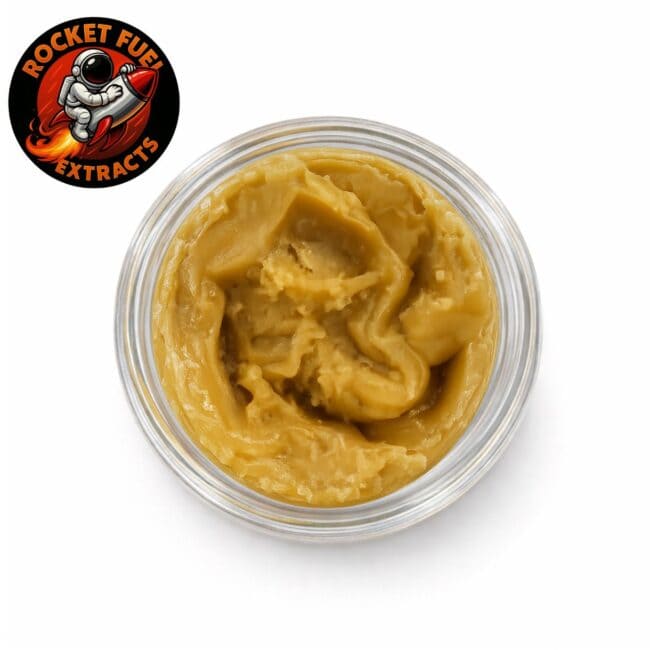 Top-down view of golden cannabis extract concentrate with smooth, creamy texture in a clear glass jar