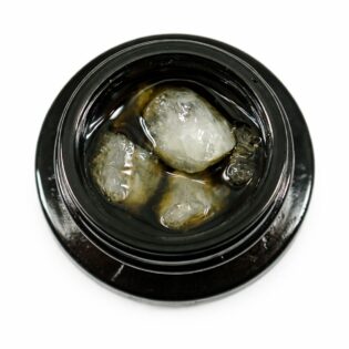 Close-up of cannabis concentrate diamonds in sauce inside a black extract jar on a white background