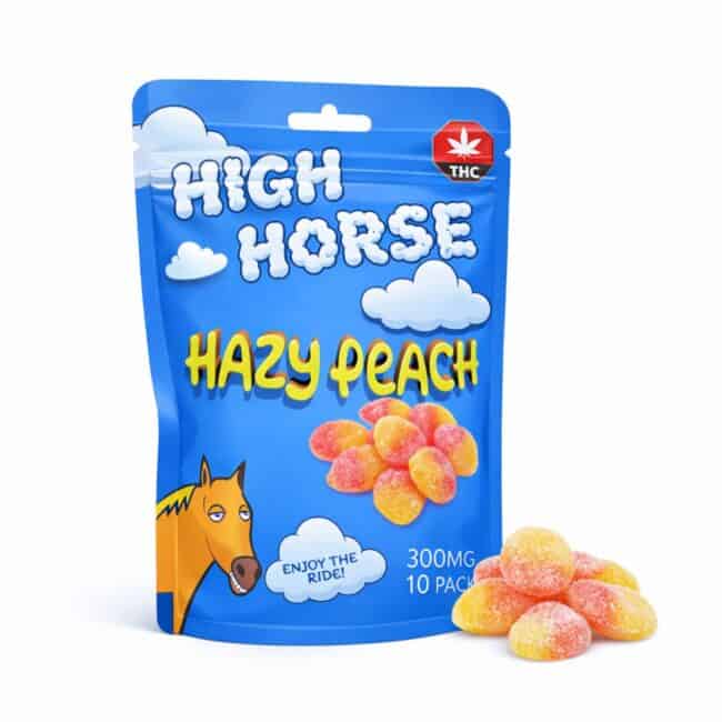 Blue resealable pouch of High Horse Hazy Peach cannabis-infused gummies featuring cloud graphics, THC symbol, illustrated horse character, and a pile of sugar-coated peach gummies displayed beside the package.