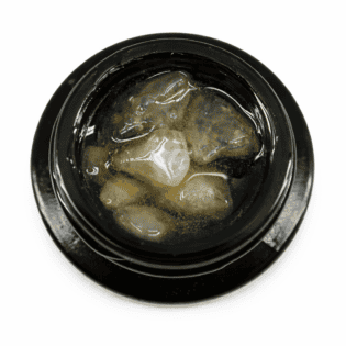 Close-up of cannabis concentrate diamonds in sauce inside a black extract jar on a white background