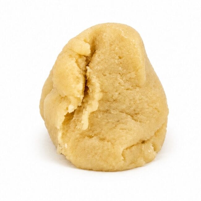 Premium light-golden cannabis concentrate with a smooth, dense texture, displayed as a sliced nug-style extract on a clean white background.