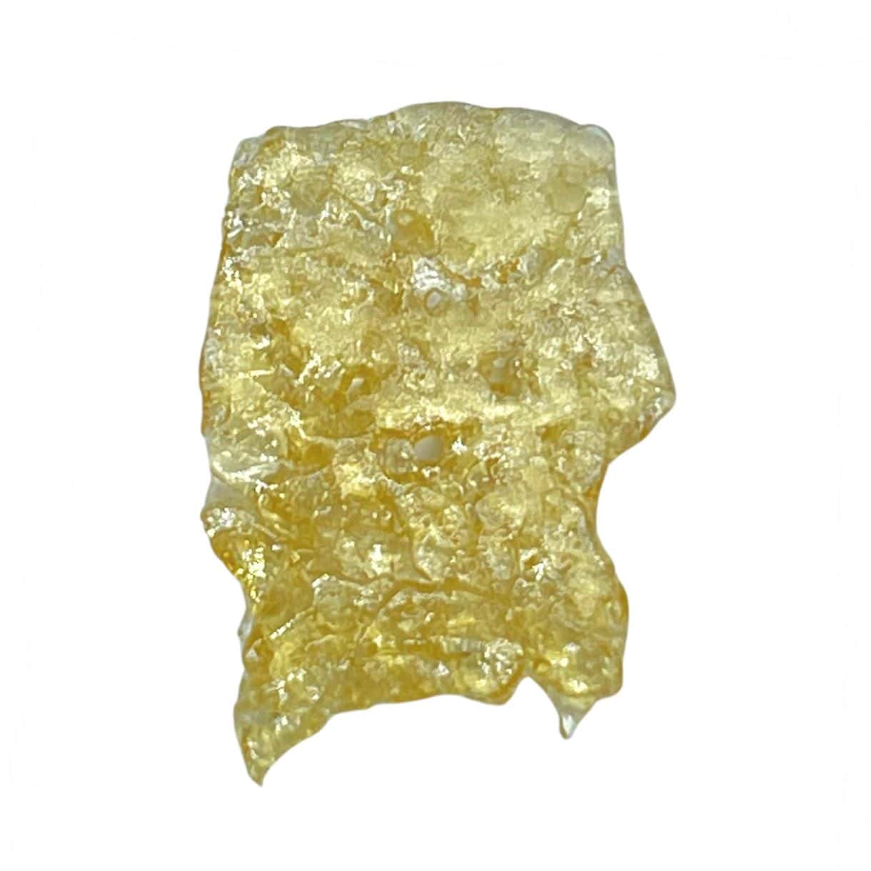 Close-up of a translucent golden cannabis concentrate slab with a porous, lace-like texture on a crisp white background.