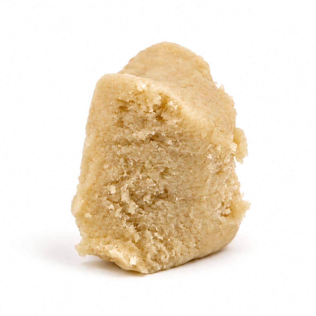 Concentré de cannabis haut de gamme, de couleur or clair, à la texture onctueuse et dense, présenté sous forme d’extrait découpé en morceaux ressemblant à des têtes, sur un fond blanc immaculé.