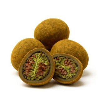 Close-up of round cannabis hash balls with one cut open to reveal a dense green and purple cannabis flower center.