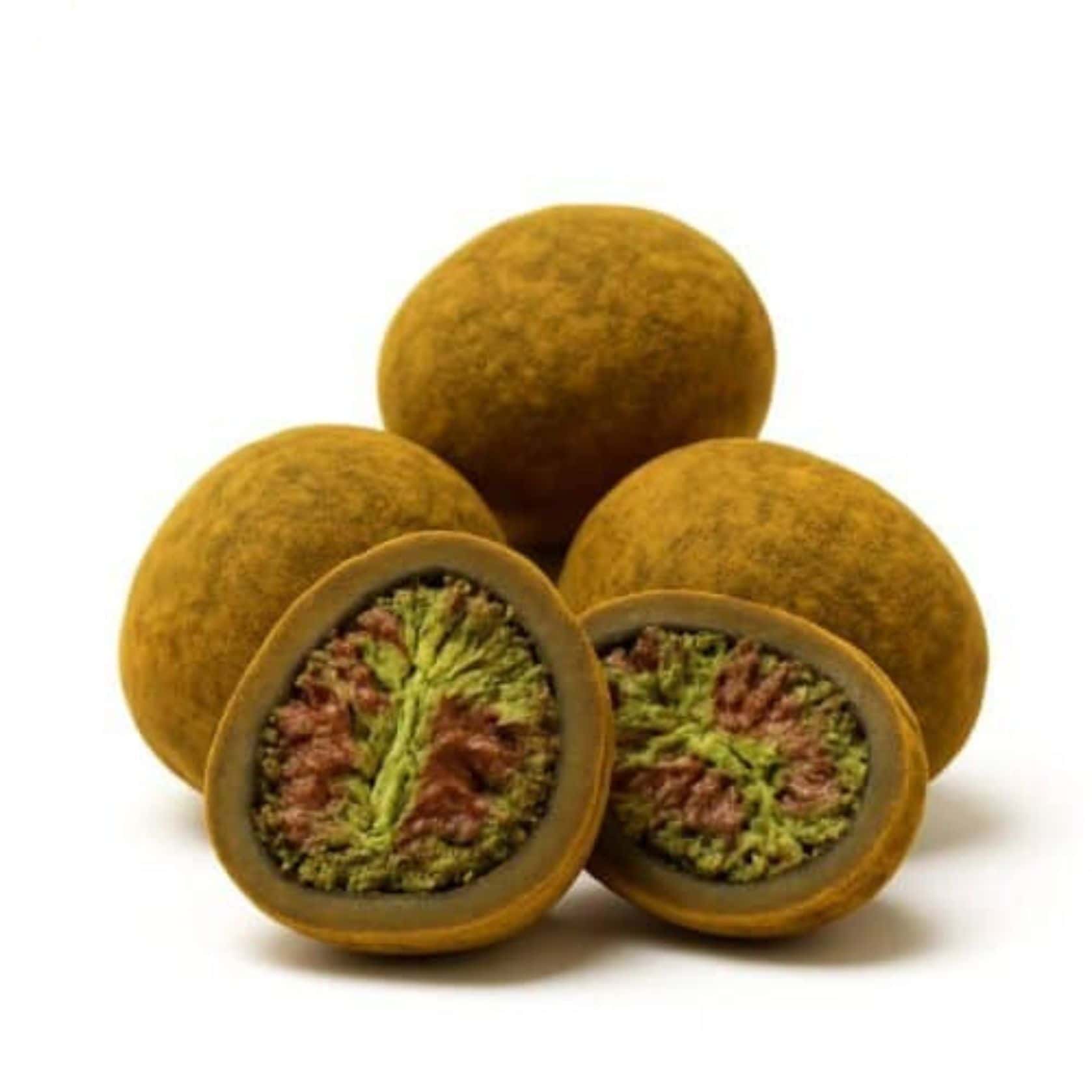 Close-up of round cannabis hash balls with one cut open to reveal a dense green and purple cannabis flower center.