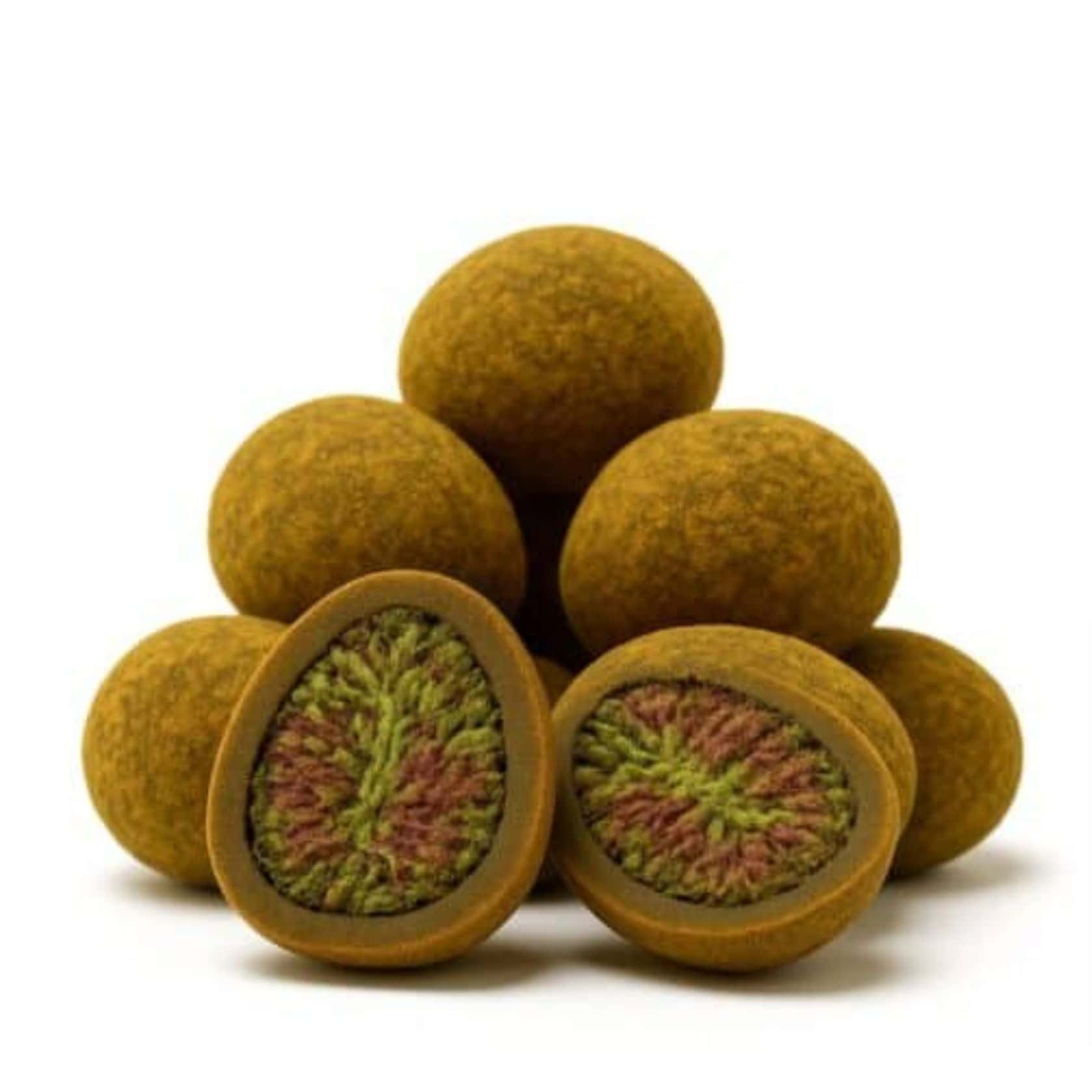 Close-up of round cannabis hash balls with one cut open to reveal a dense green and purple cannabis flower center.