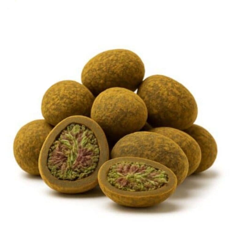 Close-up of round cannabis hash balls with one cut open to reveal a dense green and purple cannabis flower center.