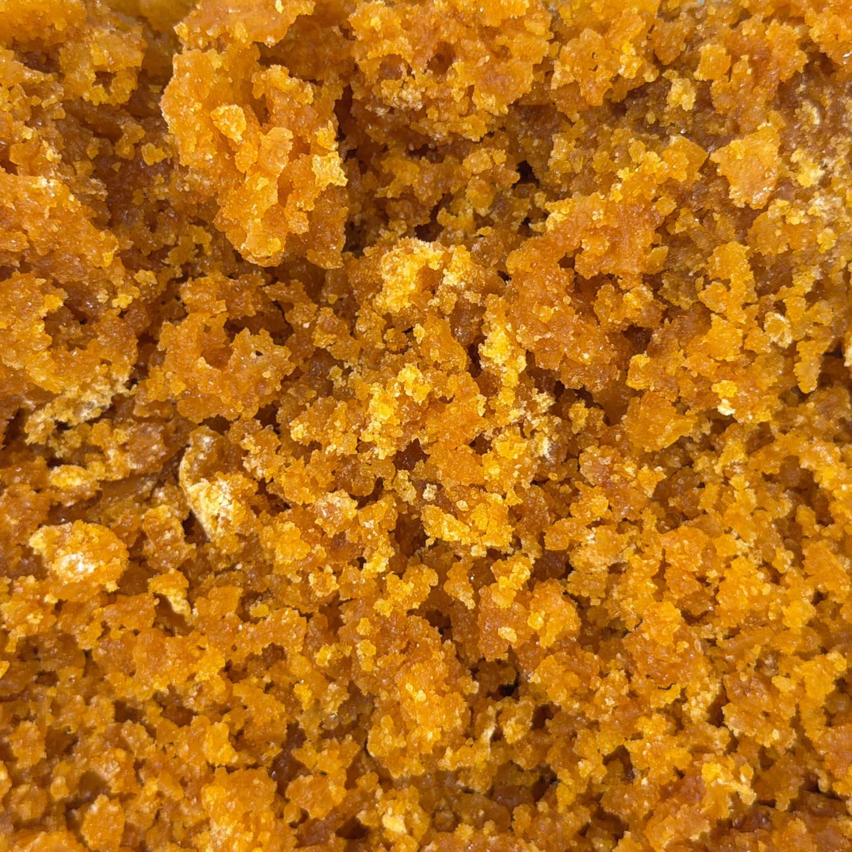 Cire de cannabis dorée haut de gamme, à la texture friable et dense, vue de près