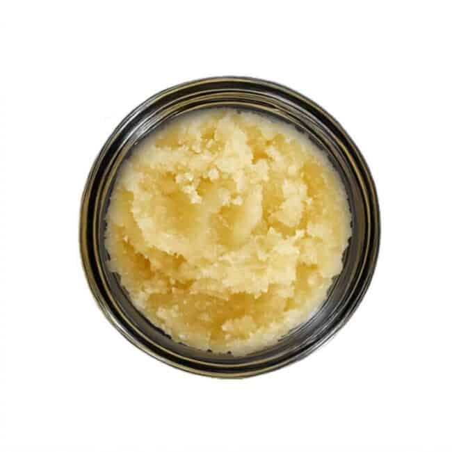 open jar with golden, crumbly texture and granular consistency (close-up)