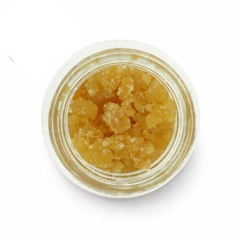Open jar with golden, crumbly texture and granular consistency (close-up)