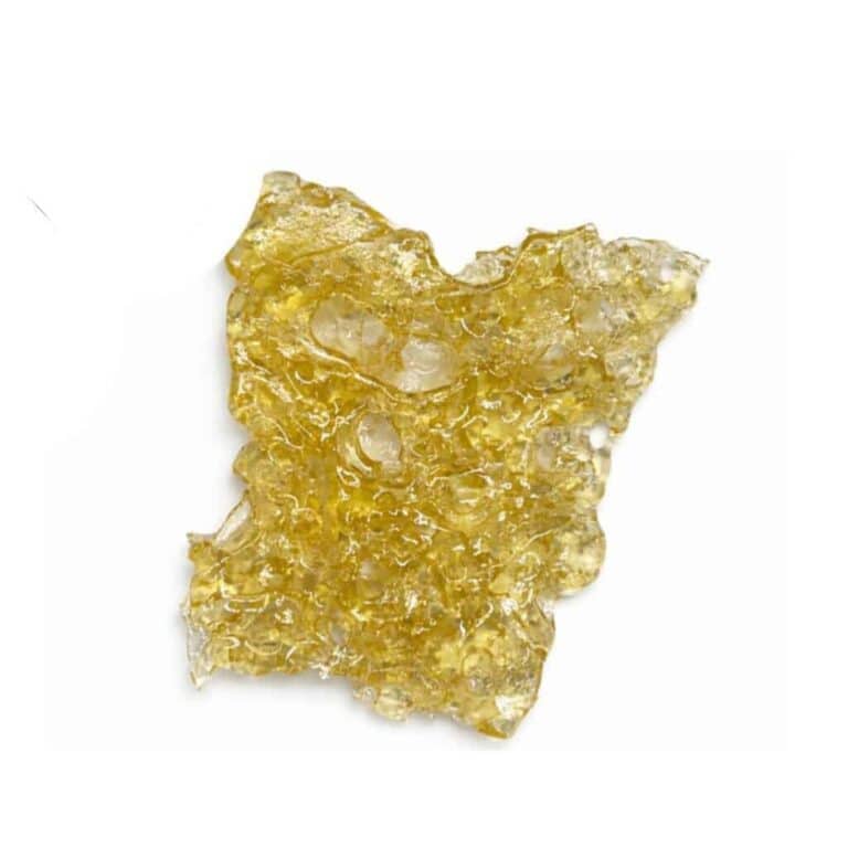 Close-up of a translucent golden cannabis concentrate slab with a porous, lace-like texture on a crisp white background.