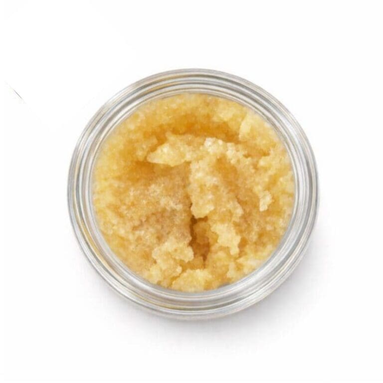 Open container of light-golden cannabis concentrate with a creamy, whipped texture on a white background.