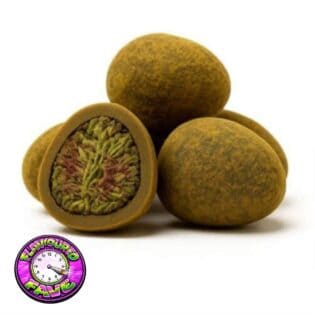 Close-up of round cannabis hash balls with one cut open to reveal a dense green and purple cannabis flower center.